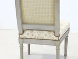 a white chair with a beige upholstered seat on it