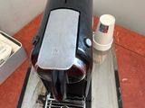 a coffee maker sitting on a table next to a cup of coffee