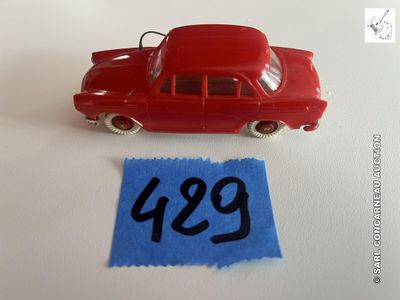 une petite voiture rouge et un bout de papier bleu posés sur une table