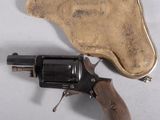 un vieux revolver posé sur un étui en cuir