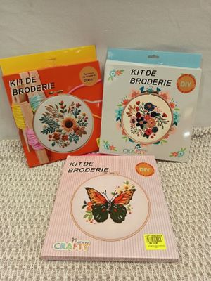 two cross stitch kits and a book on a table