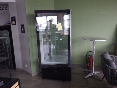 une vitrine en verre dans le coin d'une pièce