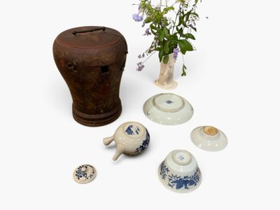 a vase with flowers in it next to other vases and bowls