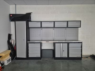 an image of a garage with a work bench and cabinets
