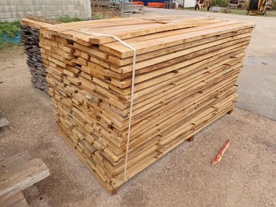 un tas de bois posé par terre devant un bâtiment
