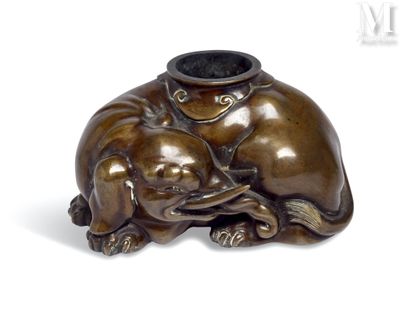 a bronze statue of a dog and a cat on a table