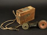 une boîte en bois et deux téléphones à l'ancienne sur fond noir