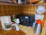 a kitchen with a microwave, coffee maker, toaster, and toaster