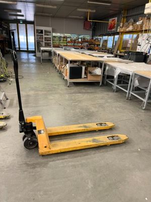 un chariot élévateur au milieu d'un entrepôt rempli de rayonnages