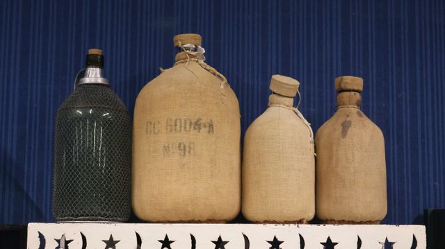 4 bouteilles anciennes dont trois recouvertes de toile de jute 