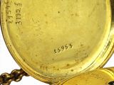 a close up of a gold pocket watch on a chain