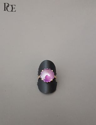 un gros plan d'une bague sertie d'une pierre rose