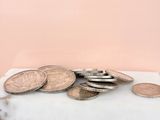 a pile of coins sitting on top of a marble counter top
