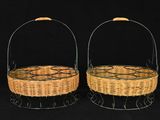 two wicker baskets with handles on a black background