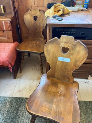 deux chaises en bois assises l'une à côté de l'autre dans une pièce