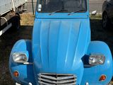 a small blue car parked in front of a building