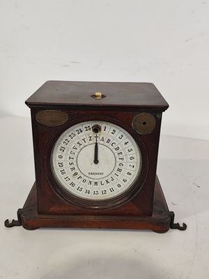 une petite horloge en bois posée sur une surface blanche