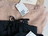 three pairs of pants with price tags on them sitting on a table