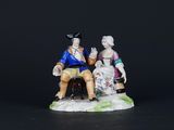 a figurine of a man and a woman sitting on a bench