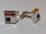 pair of silver cufflinks with a blue stone in the center
