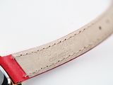 a close up of a wrist watch with a red strap