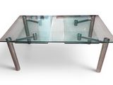 une table en verre avec des pieds en métal et un plateau en verre