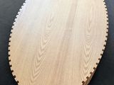 a round wooden cutting board sitting on top of a table