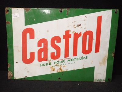 une vieille enseigne « Castrool » posée sur une table noire