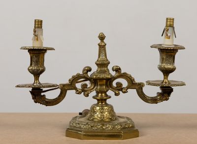 un candélabre en laiton sur une table, sur lequel sont posées trois bougies