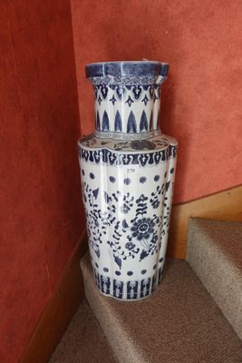 un grand vase bleu et blanc posé sur les marches