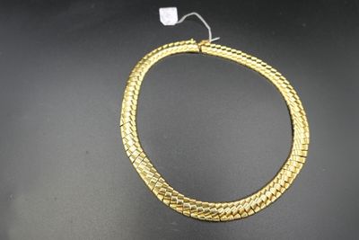 gros plan d'un collier en or sur une surface noire