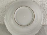 a white plate with a brown rim sitting on a table