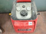 a red and black machine sitting on a wooden floor