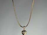 a gold necklace with a heart pendant on a chain