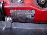 a close up of a red motorcycle with a number plate on it