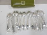 six silver spoons in a package on a table