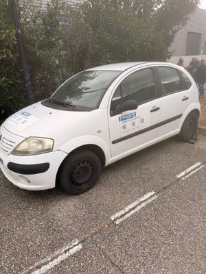 une petite voiture blanche garée dans un parking