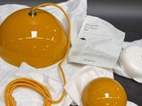 a yellow lamp that is sitting on a white cloth