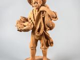statue d'un garçon portant un panier de fruits sur l'épaule