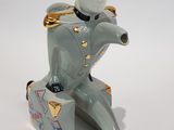 a figurine of a man sitting on top of a suitcase