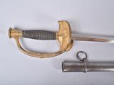 a sword and two other items on a white surface