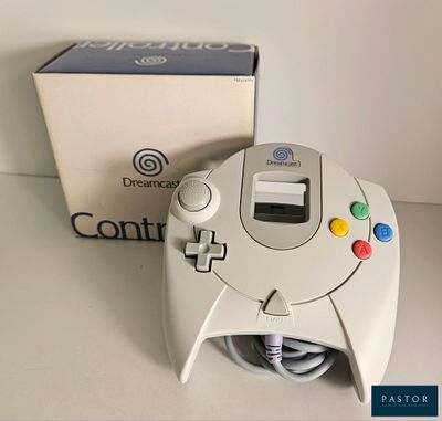 une manette de jeu vidéo posée sur une table à côté d'une boîte