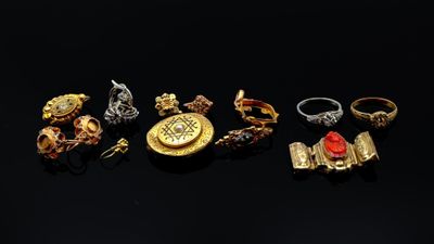 un ensemble de bagues et d'autres bijoux posés sur une surface noire