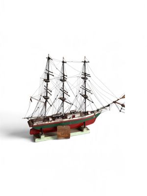 une petite maquette de bateau posée sur une surface blanche