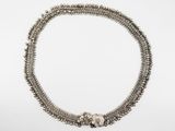 a close up of a silver necklace on a white background