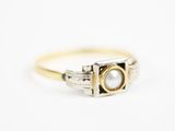 gros plan d'une bague en or contenant une perle
