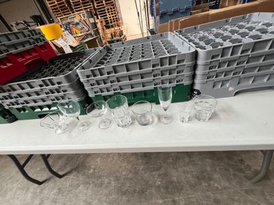 de nombreux verres à vin vides posés sur une table dans un entrepôt