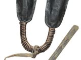 a pair of black leather shoes that are next to a wooden stick