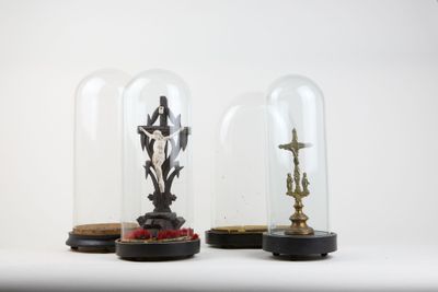 two glass cloches with statues inside of them