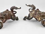 pair of antique bronze elephants on wheels on a white background